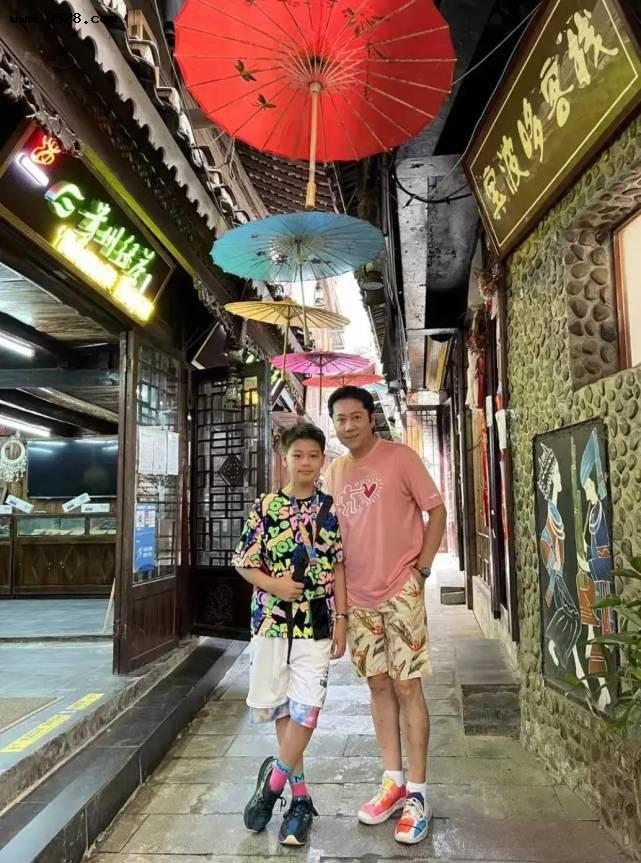 50多岁蔡国庆带儿子旅游，粉色T恤配花裤子年轻活力，状态像20岁